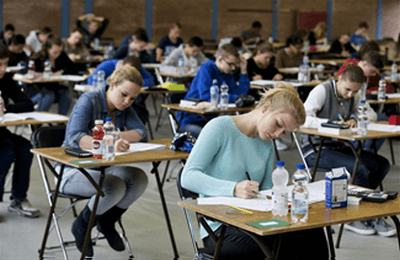 leerlingen doen examen in een grote zaal